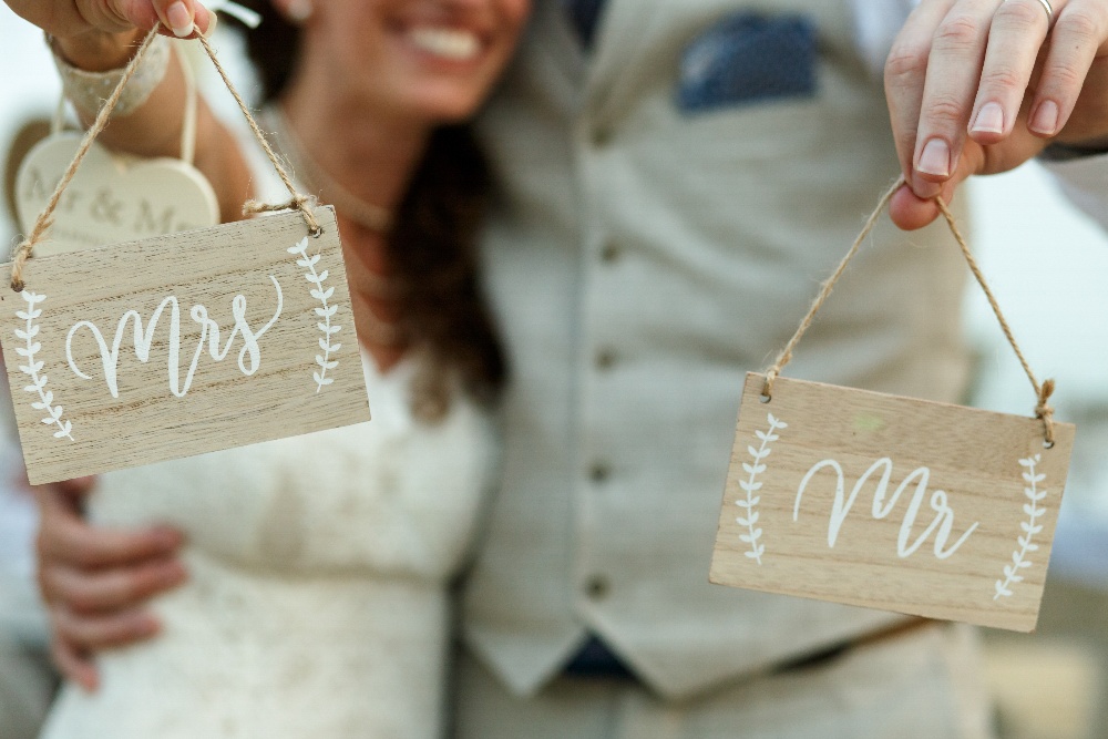 happy-newlyweds-hold-wooden-boards-with-letterings-mrs-mr-1